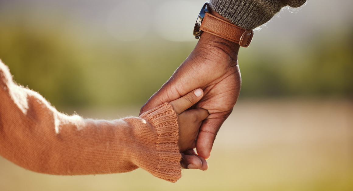 Family, holding hands and girl with father closeup in a park, hands and walking in nature, bond and relax outdoors. Love, trust and parent hands with child in support of trust, peace and unity.