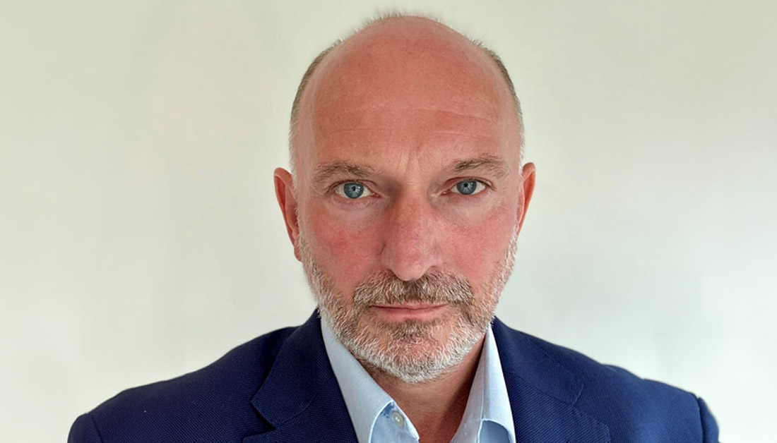 A head and shoulders photograph of Mark Lloyd, wearing a dark blue suit jacket and light blue shirt.
